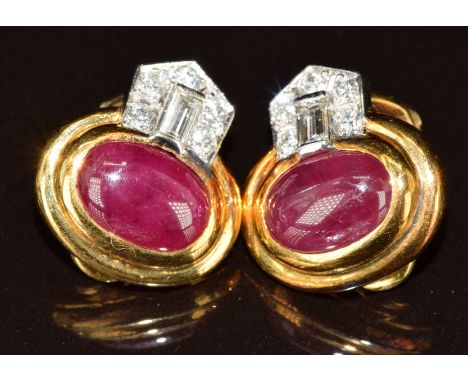 A pair of 18k gold earrings each set with a ruby cabochon of approximately 2.6ct, five round cut diamonds and one baguette cu