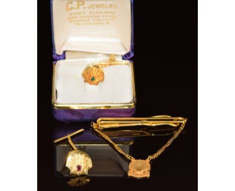 A 22k gold shell stud set with an emerald (2.6g) yellow metal shell stud set with a ruby (2.9g) and a '10 years of service' 1