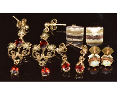 Four pairs of&nbsp;9ct gold earrings including two set with garnets, one opal and the other pair tri-coloured, 6.6g
