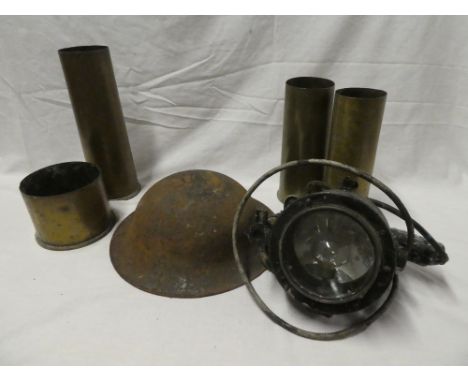 Four various First War brass shell cases, Second War steel helmet and a signalling lamp