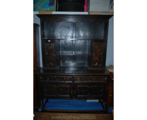 A 1930's Oak Dresser, having moulded cornice and fret-cut detail to the twin cupboard and twin shelf plate rack, the base hav