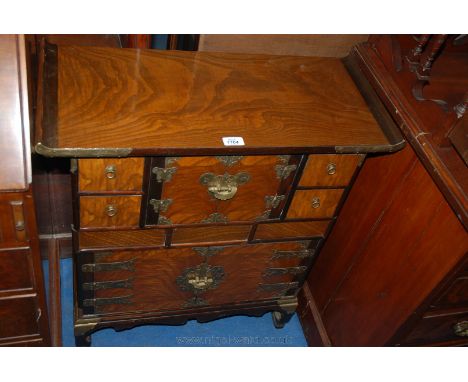 A reproduction Oak oriental style Cabinet having single plank top with carved cleated ends, upper central pair of opposing si