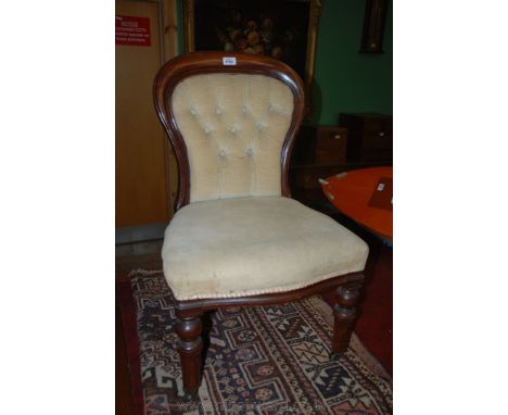 A Victorian Mahogany framed Nursing Chair, hooped back with cream draylon button back and seat, on turned and fluted legs wit