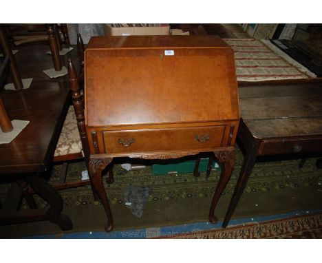 A reproduction Walnut finished Queen Anne style Bureau, having burr top and half veneered fall opening to reveal five pigeon 