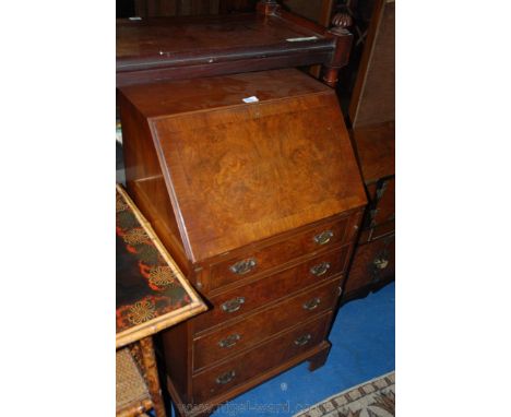 A reproduction Walnut finished Georgian style Bureau, having plain top, the half burr veneered fall opening to reveal green l