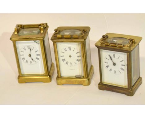 Group of three late 19th/early 20th century brass carriage clocks, white enamel dials and Roman numerals, complete with keys,
