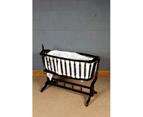 Victorian style wooden crib, having bobbin turned spindles and raised on stand, 118cm wide