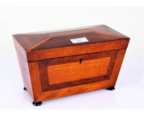 Regency mahogany tea caddy, of sarcophagus form, the inlaid hinged lid enclosing a two compartment interior, raised on four b