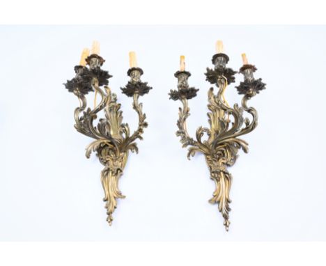 A pair of French Louis XV style bronze three-light wall lights with floral design, 19th/20th C.H 58 cm