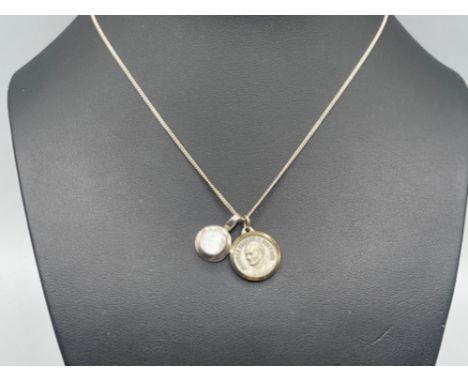 Silver necklet with silver mother of pearl pendant alongside a religious pendant weighing 4.8 grams