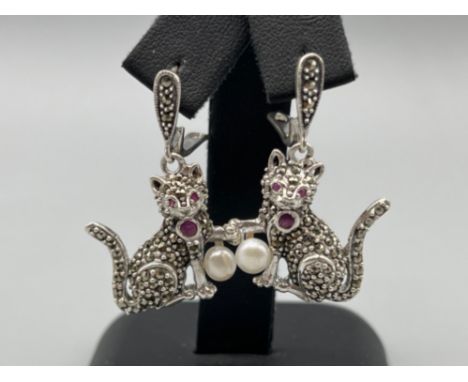 A pair of silver and marcasite cat drop earrings with ruby eyes