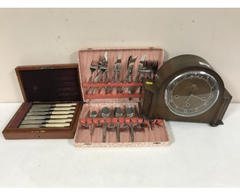 An oak Smiths mantel clock, two canteens of plated fish cutlery and stainless steel cutlery 
