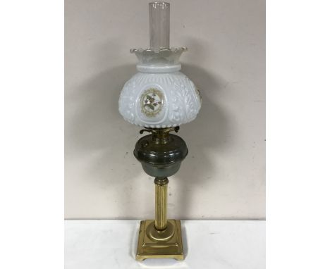 An antique brass oil lamp with brass shade and chimney 