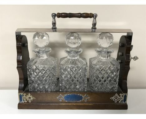 A Victorian style three decanter Tantalus with silver plated mounts 