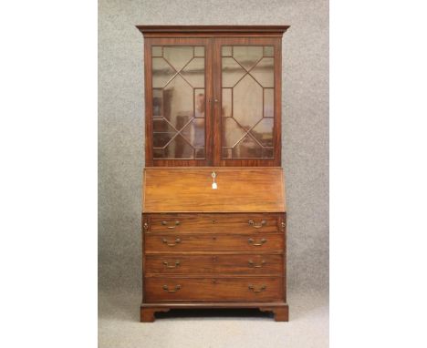 A GEORGIAN GONCALO ALVES(?) VENEERED MAHOGANY BUREAU BOOKCASE, late 18th century, the dentil moulded cornice over astragal gl