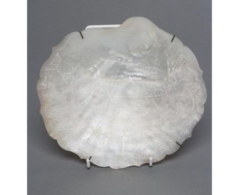 A CHINESE MOTHER OF PEARL DISH with fret carved lobed rim, engraved with an armorial within a border of figures at their dail