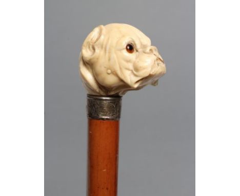 A VICTORIAN MALACCA WALKING STICK, the ivory grip carved as a bulldog's head with glass eyes, leaf chased silver collar (Lond