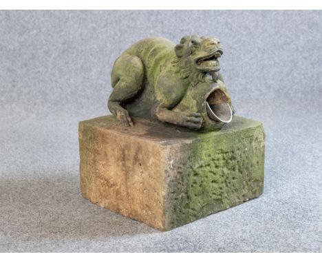 A CARVED SANDSTONE GARGOYLE, probably late 19th century, modelled as a squatting mythical beast holding a water outlet, on ob