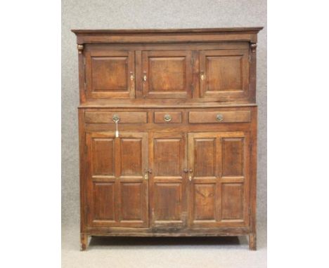 AN OAK DEUDARN, late 18th century, the moulded cornice and plain frieze with turned end pendants over three recessed cupboard