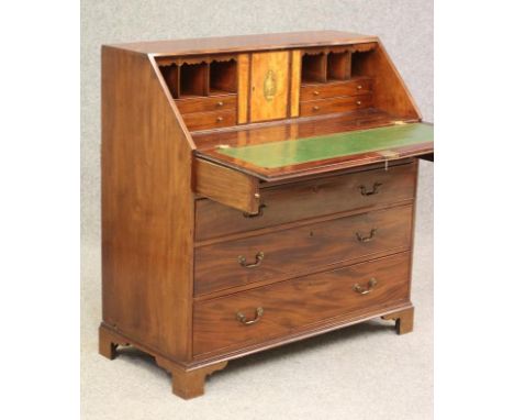 A GEORGIAN MAHOGANY BUREAU, late 18th century, the fall front enclosing interior with cupboard door with urn patera flanked b