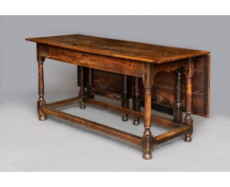 A CUMBRIAN OAK FARMHOUSE KITCHEN TABLE, mid 18th century, the cleated plank top with a single leaf on gate supports, plain fr