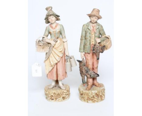 A PAIR OF ROYAL DUX FIGURES, early 20th century, modelled as a young hunter with a basket over his left arm and holding a bra