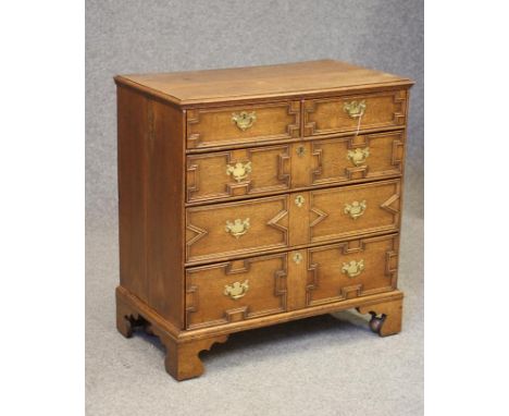 AN OAK GEOMETRIC CHEST, early 18th century, the moulded edged top over two short and three long drawers with later brass drop