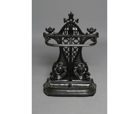 A VICTORIAN CAST IRON STICK STAND of rounded oblong form, the trellis pierced and waisted back with arched surround and urn f