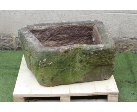 A SANDSTONE TROUGH of irregular rough hewn oblong form, 35 1/2" x 25" x 17" (Est. plus 21% premium inc. VAT)