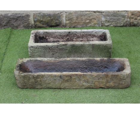 A SANDSTONE TROUGH of narrow oblong form, finely cut with rounded front corners, 40" x 11" x 65", together with another, simi