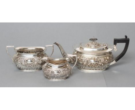 AN EDWARDIAN SILVER THREE PIECE TEA SERVICE, maker S Glass, Birmingham 1902, of rounded oblong form chased and repousse with 