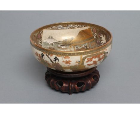 A SATSUMA EARTHENWARE BOWL, the interior painted in typical enamels with a harbour scene, a family beneath a tree and a snow 