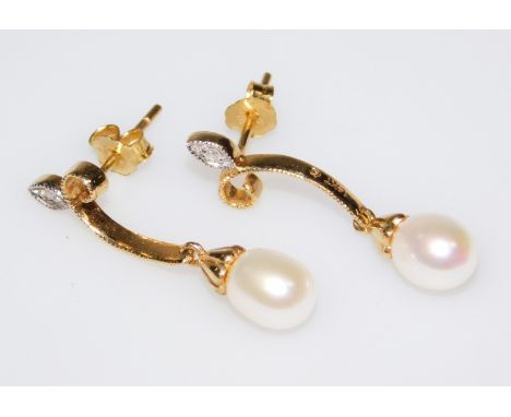 A pair of pearl and diamond earrings, the cultured pearl single drops, and scroll design set with tiny white stones, with but