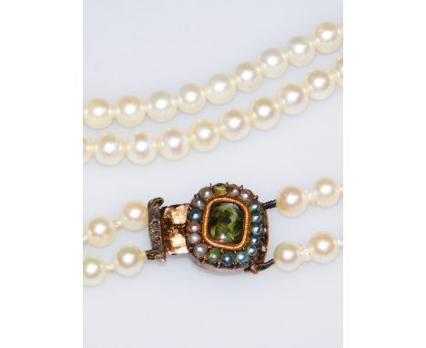 A two strand cultured pearl necklace, set with blue seed pearls, with a memorial panel to the centre set with a locket of hai