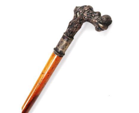 An early 20thC turned fruit wood walking stick, with elaborate handle formed as a sleeping cherub on a naturalistic setting, 