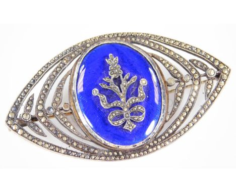A marquise shaped brooch, blue enamel front panel with applied marcasite set bow and ribbon decoration, the whole in white me