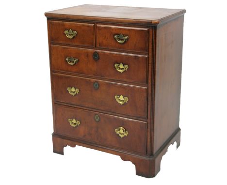 A 20thC walnut veneered chest of two short and three long drawers, each with swan neck plate back handles, flanked by fluted 