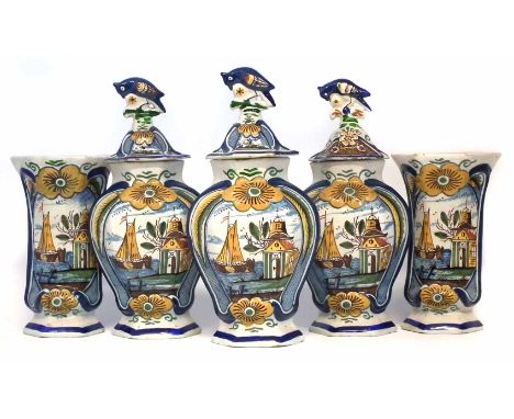 Garniture of five Delft vases, three with bird finial covers, the bodies of hexagonal form moulded with a large flower head, 