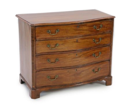 A George III mahogany serpentine dressing chest, with straight sides and fitted four graduated long drawers with brass loop h