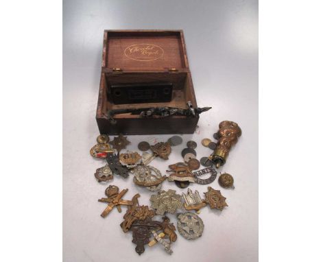 A copper and brass 'serpent' body powder flask and various regimental cap badges