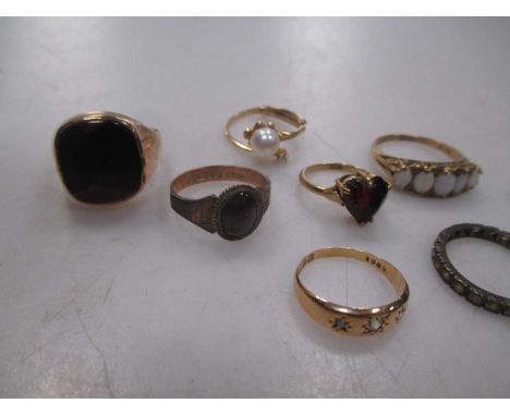 A 9ct opal five stone ring, a 9ct garnet ring, another garnet ring marked '9ct', an onyx signet ring, a pearl ring marked '58