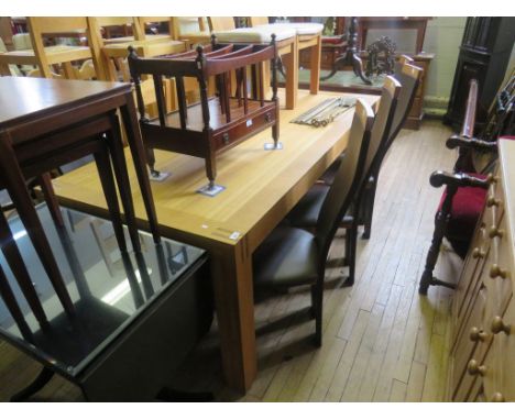 A contemporary light oak dining table, raised upon substantial legs of square section, along with a set of eight light oak an