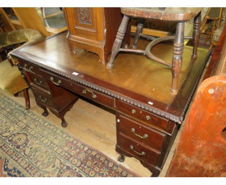 A mahogany twin pedestal office desk, raised on short legs and ball and claw feet 