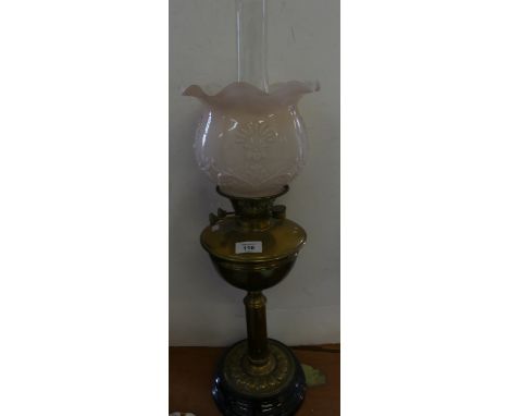 A brass based oil lamp with frilled opaque glass shade 