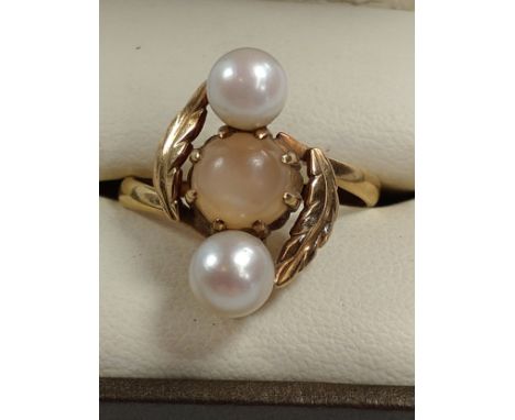 A gold colour metal ring set with two pearls and a cat's eye. Size R. provenance 80 rose Street Wokingham. 