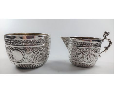 A highly decorated cream jug and sugar basin 