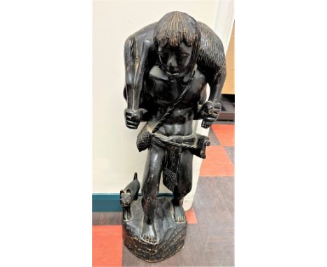 A Vintage carved Wood Figure of a Hunter. Shown carrying a dead Deer and with a dog at his side. 77cm high. Possible Black Fo