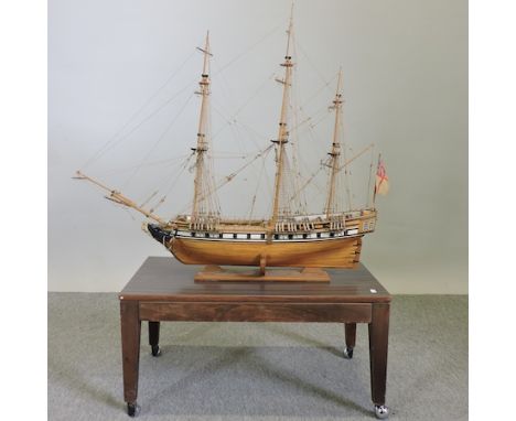 A wooden model of a three masted ship, on a base, 107cm tall overall 