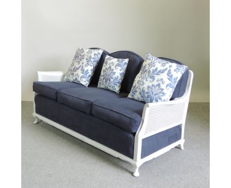 An early 20th century and later white painted bergere three seater sofa, newly upholstered in blue fabric, 160cm