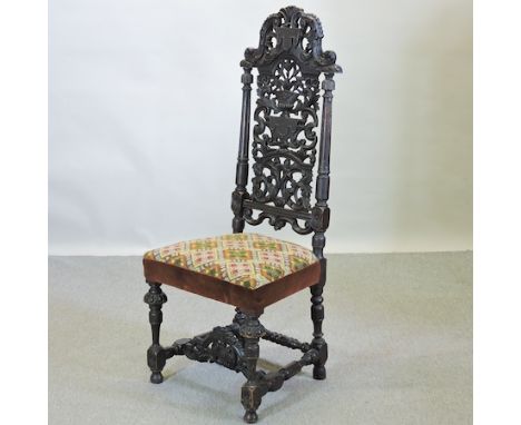 A 19th century heavily carved dark oak hall chair, with a tapestry seat